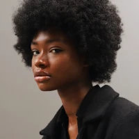 Portrait of a woman with curly hair wearing a black top